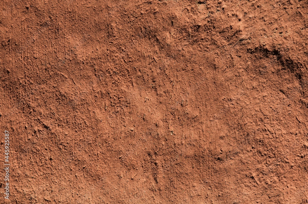 Brown clay background and uneven texture. Orange, brown, terracotta, scorched, desert surface. Natural ecological coating in residential construction. Martian species. Natural background