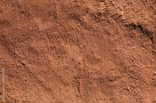 Brown clay background and uneven texture. Orange, brown, terracotta, scorched, desert surface. Natural ecological coating in residential construction. Martian species. Natural background