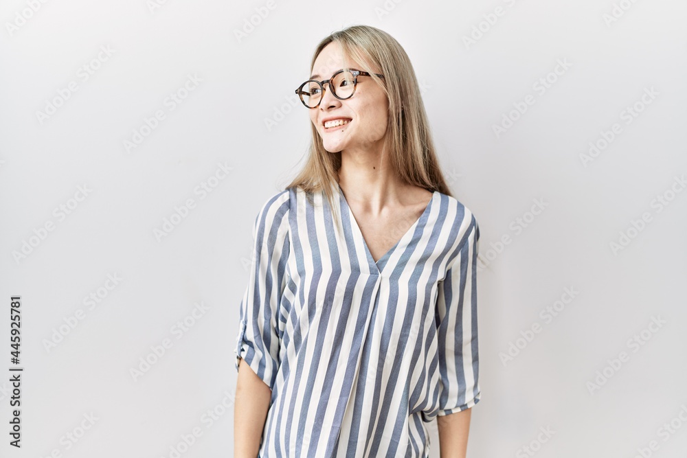 Asian young woman wearing casual clothes and glasses looking away to side with smile on face, natural expression. laughing confident. Asian young woman wearing casual clothes and glasses looking away to side with smile on face, natural expression. laughing confident.