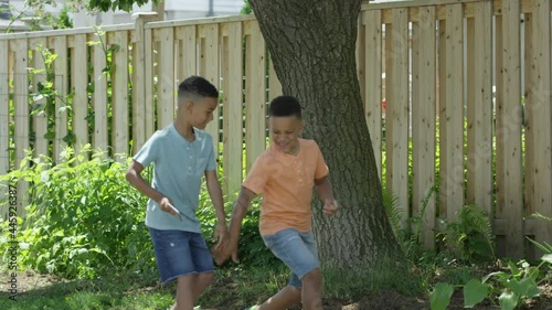 Brothers walking down street one knocks phone from others hands photo