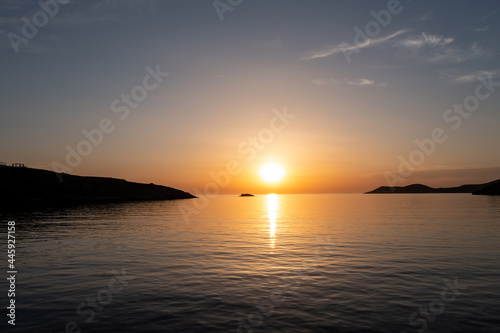 Sunset over calm sea, orange color sky background. Aerial drone view, Greece