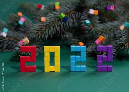 Christmas composition with a fir tree branch and colorful cubes from a children's constructor. Namber 2022 from magnet cubies. photo