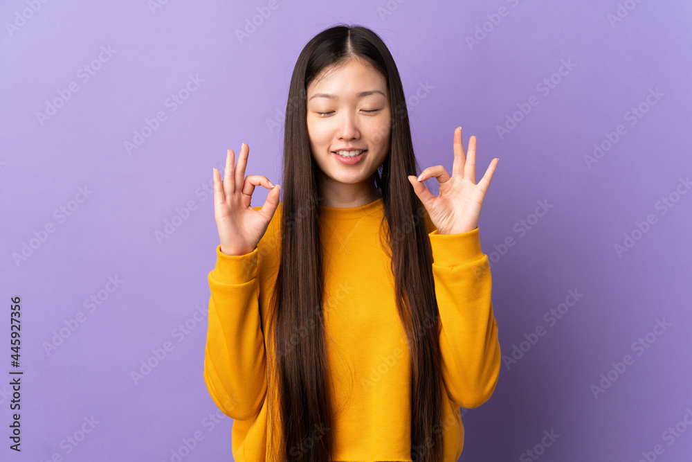Young Chinese girl over isolated purple background in zen pose Young Chinese girl over isolated purple background in zen pose