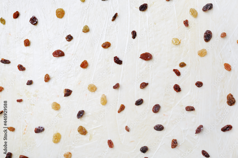 Raisins on the background of rolled dough. Flat lay. Raisins on the background of rolled dough. Flat lay.