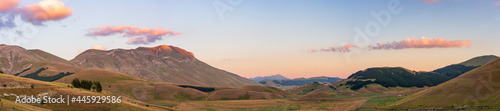 Sunset over blooming cultivated fields, famous colourful flowering plain in the Apennines, Castelluccio di Norcia highlands, Italy. Agriculture of lentil crops. photo