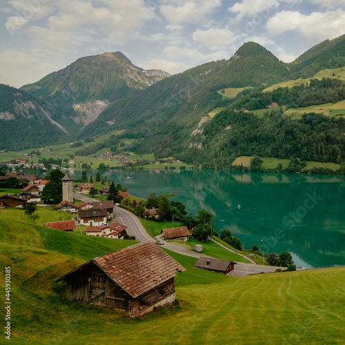 Swiss village Lungern with its traditional houses and old church tower Alter Kirchturm along lovely emerald green lake Lungerersee, canton of Obwalden, Switzerland - Swiss Alps, Brunig Pass photo