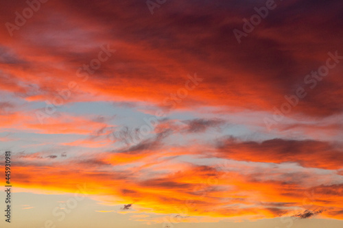 Fototapeta Naklejka Na Ścianę i Meble -  Der Sonnenuntergang bringt den Himmel zum Leuchten in orange, gelb, rot, blau, schwarz, weiß.