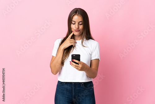Young Uruguayan woman isolated on pink background thinking and sending a message