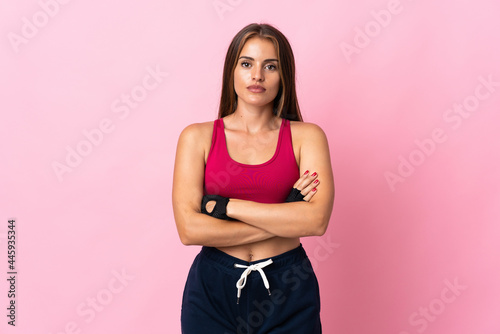 Young Uruguayan woman isolated on pink background with arms crossed