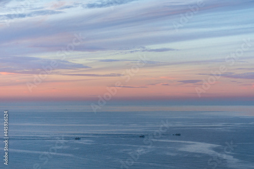 Fishing boats on a fishing trip in the Mediterranean sea with sunset  blue sky and clouds  fishing in the sea  aerial photo of a boat at sea.