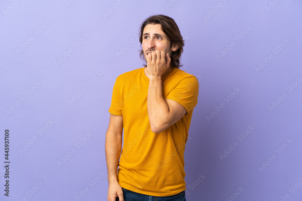 Young handsome man isolated on purple background is a little bit nervous Young handsome man isolated on purple background is a little bit nervous