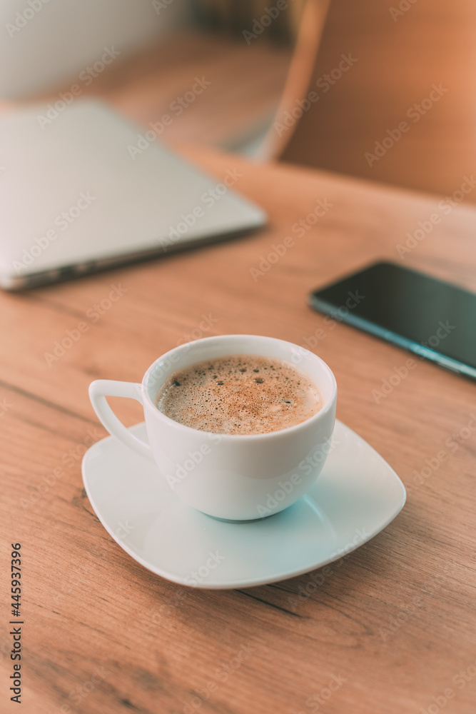 Fototapeta premium Coffee cup with laptop computer and mobile smart phone on freelancer's desk