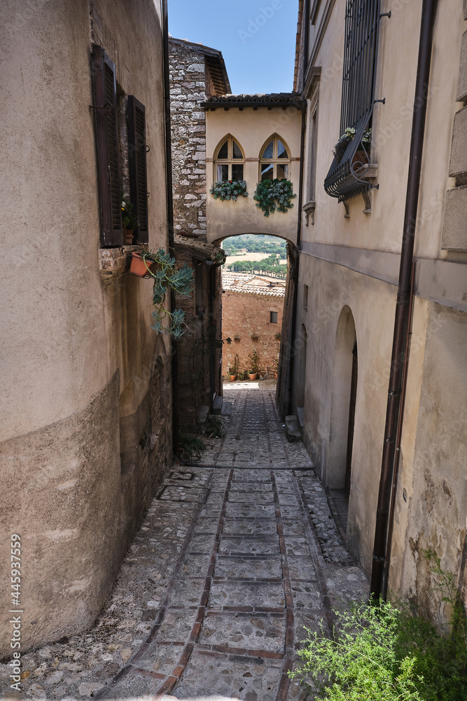 alley with inhabited bridge in the medieval town of spello umbria