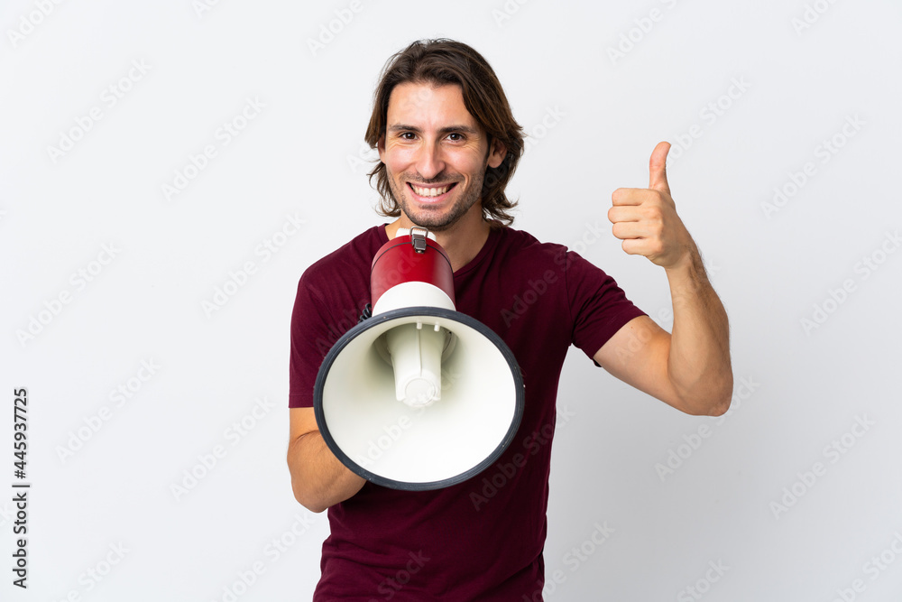 Young handsome man isolated on white background shouting through a megaphone to announce something and with thumb up Young handsome man isolated on white background shouting through a megaphone to announce something and with thumb up