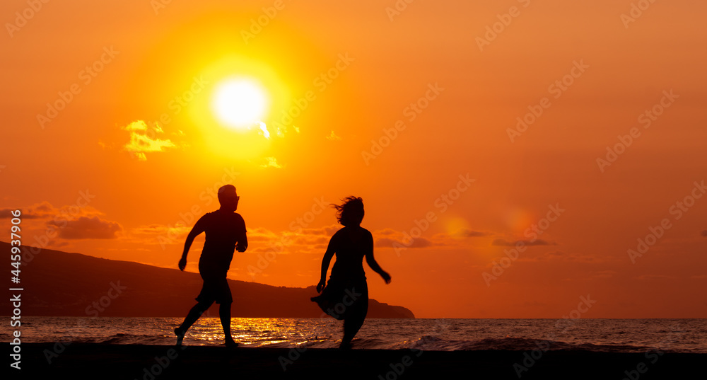 Harmony between couple at the beach, silhouette during sunset, lovers.