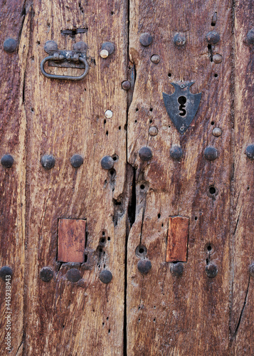 Puerta antigua de madera con herrajes oxidados