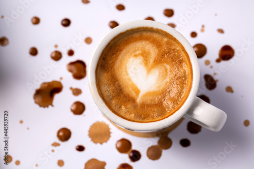 Heart shaped latte coffee art in espresso cup placed on white background