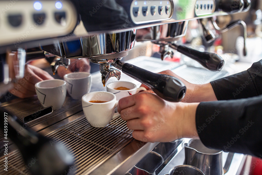Barista preparing an espresso in a coffee machine, close up fresh coffee