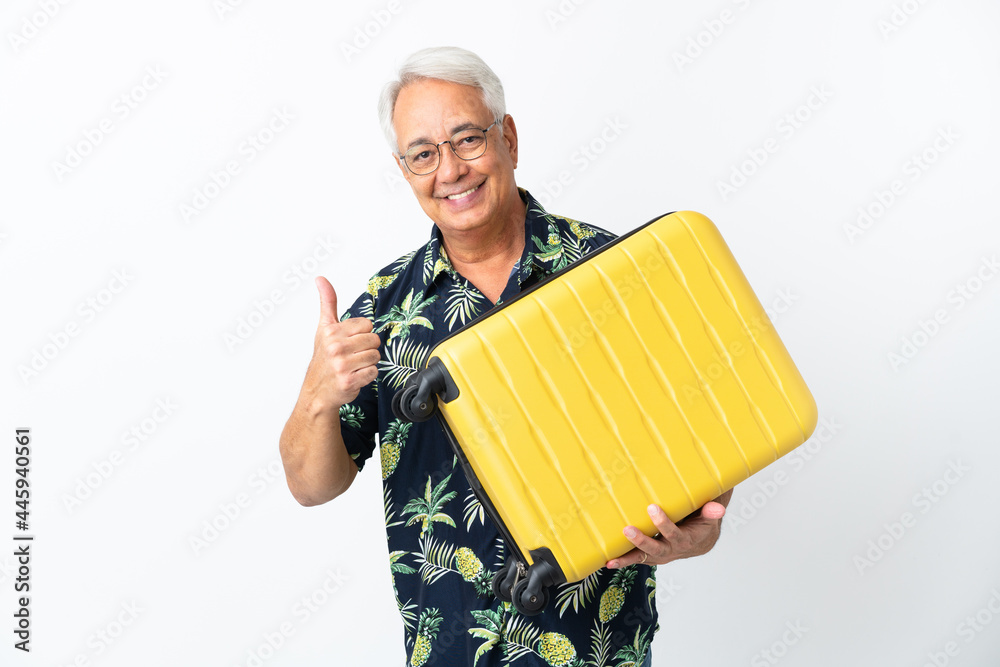 Middle age Brazilian man isolated on white background in vacation with travel suitcase and with thumb up Middle age Brazilian man isolated on white background in vacation with travel suitcase and with thumb up