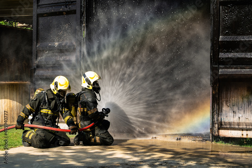 Firefighters are conducting fire drills by spraying water to extinguish the raging fire.