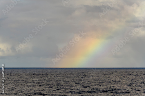 Rainbow at sea. Seascape, blue sea. Calm weather. View from vessel. 