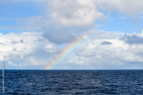 Rainbow at sea. Seascape  blue sea. Calm weather. View from vessel.  