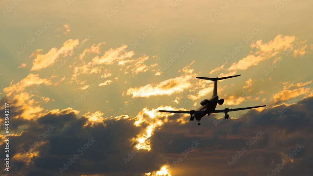 The plane is landing against the backdrop of a dramatic sky at sunset. airlines, flight, travel, tourism, trip.