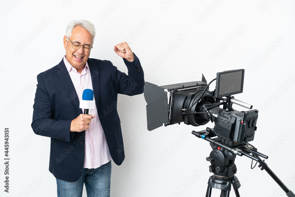 Reporter Middle age Brazilian man holding a microphone and reporting news isolated on white background celebrating a victory