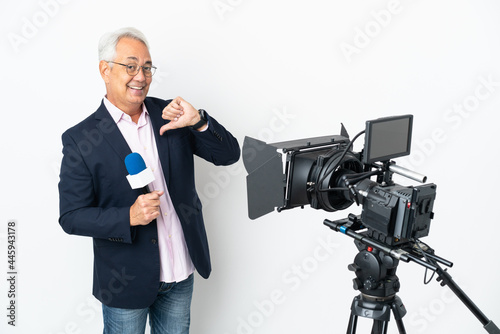 Reporter Middle age Brazilian man holding a microphone and reporting news isolated on white background proud and self-satisfied
