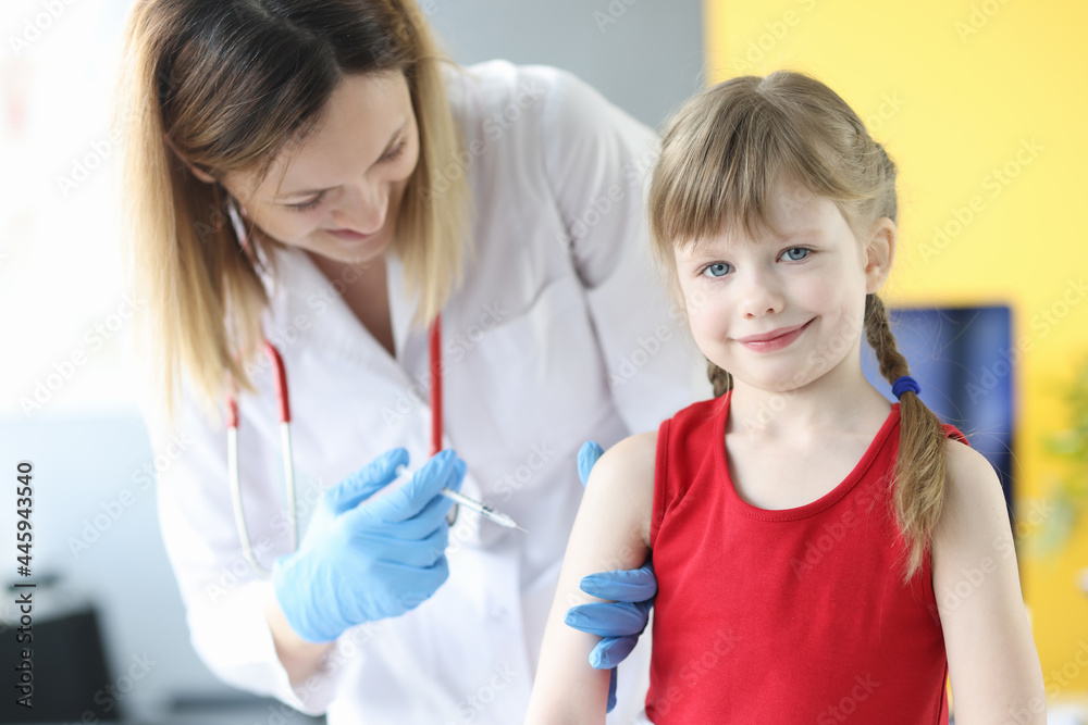 Doctor injects little girl in shoulder closeup Doctor injects little girl in shoulder closeup