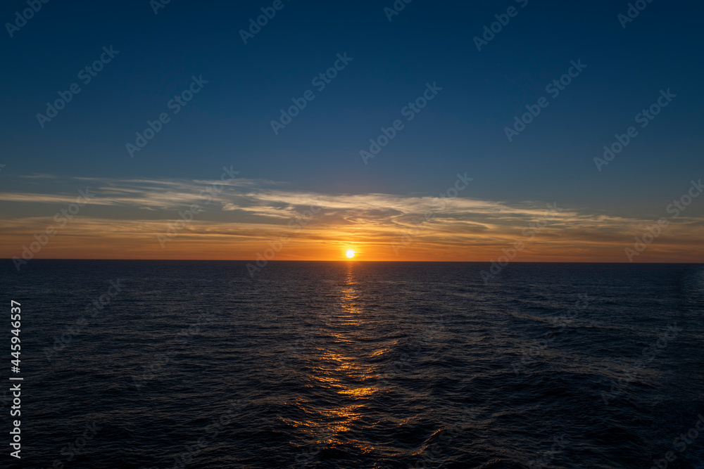 Sunset at sea. Seascape, blue sea.  Calm weather. View from cargo vessel.