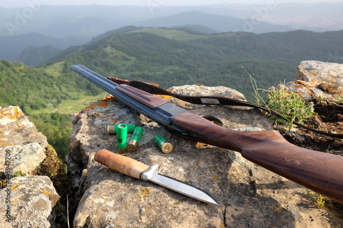 hunting gun and knife in mountains