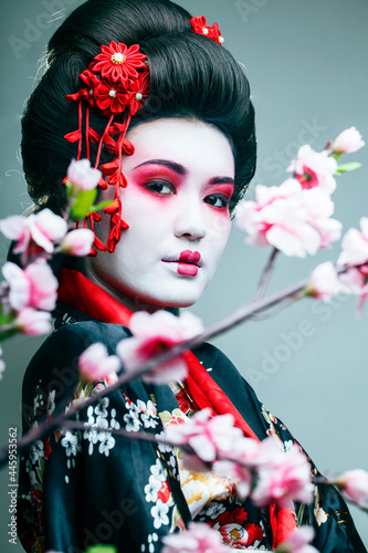 Quadro em tela young pretty geisha in black kimono among sakura, asian ethno close up on white