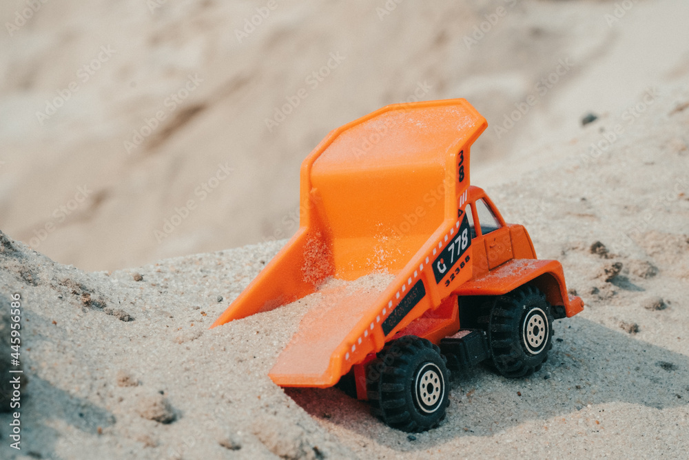 Truck in a sand quarry. Large excavator loads rock with iron or bauxite mining dump truck in a quarry against the sky Truck in a sand quarry. Large excavator loads rock with iron or bauxite mining dump truck in a quarry against the sky