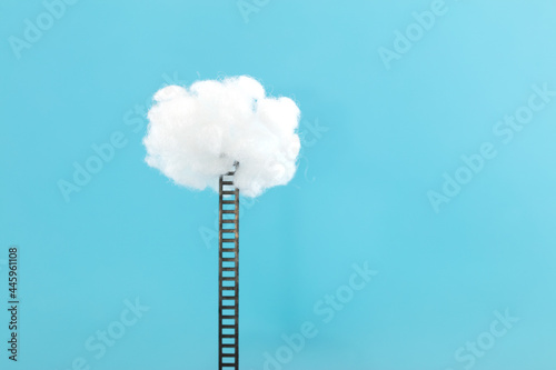Ladder leading to the clouds on blue background