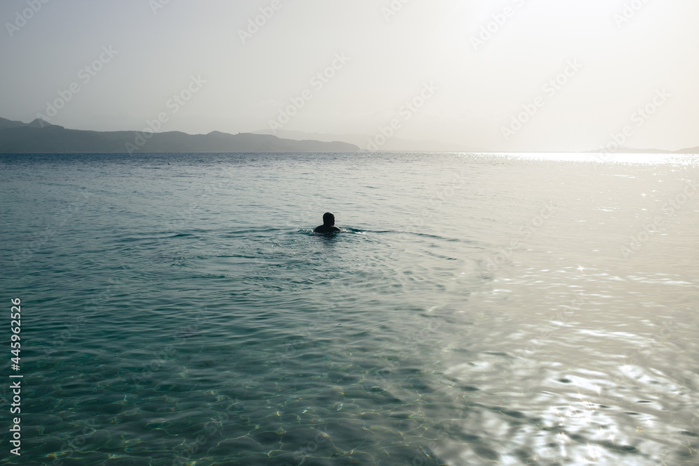 Fototapeta premium Person in Wide Ocean with Coast in Sight