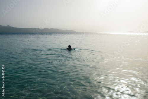 Person in Wide Ocean with Coast in Sight