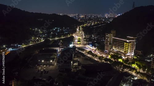 Aerial hyperlapse backwards over avenue with traffic at night. Drone flight above lighting city of Tapei Cityscape.New taipei city,Taiwan. photo