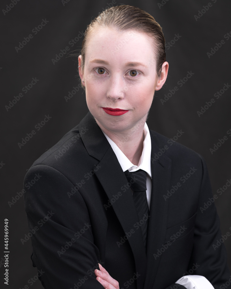 Young woman with short blonde hair poses before a dark background. Young woman with short blonde hair poses before a dark background.