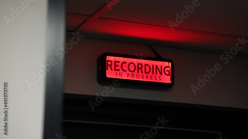 Side shot of red recording light at a music studio switching on and off. Off air.