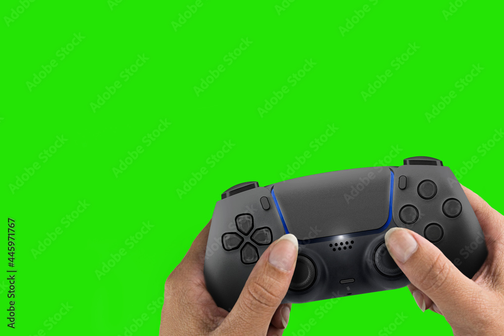 Female hand holding a Next Generation black game controller isolated on green screen background. Chroma Key. Female hand holding a Next Generation black game controller isolated on green screen background. Chroma Key.