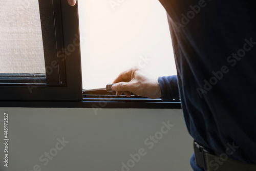 Man doing aluminum frame with wire screen door and window installation work in construction site