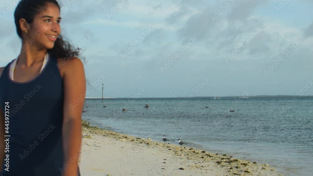 young latin girl walking on the tropical beach take off covi mask young latin girl walking on the tropical beach take off covi mask