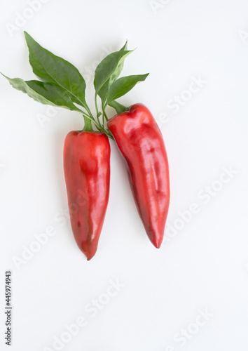 Red ''Corno di Toro'' Peppers with Leaves on White Background