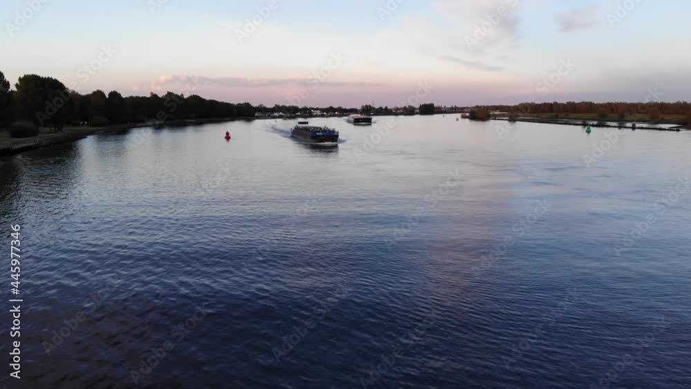 Empty Cargo Vessels Navigating The Calm River In Barendrecht, Netherlands At Dusk. aerial Empty Cargo Vessels Navigating The Calm River In Barendrecht, Netherlands At Dusk. aerial