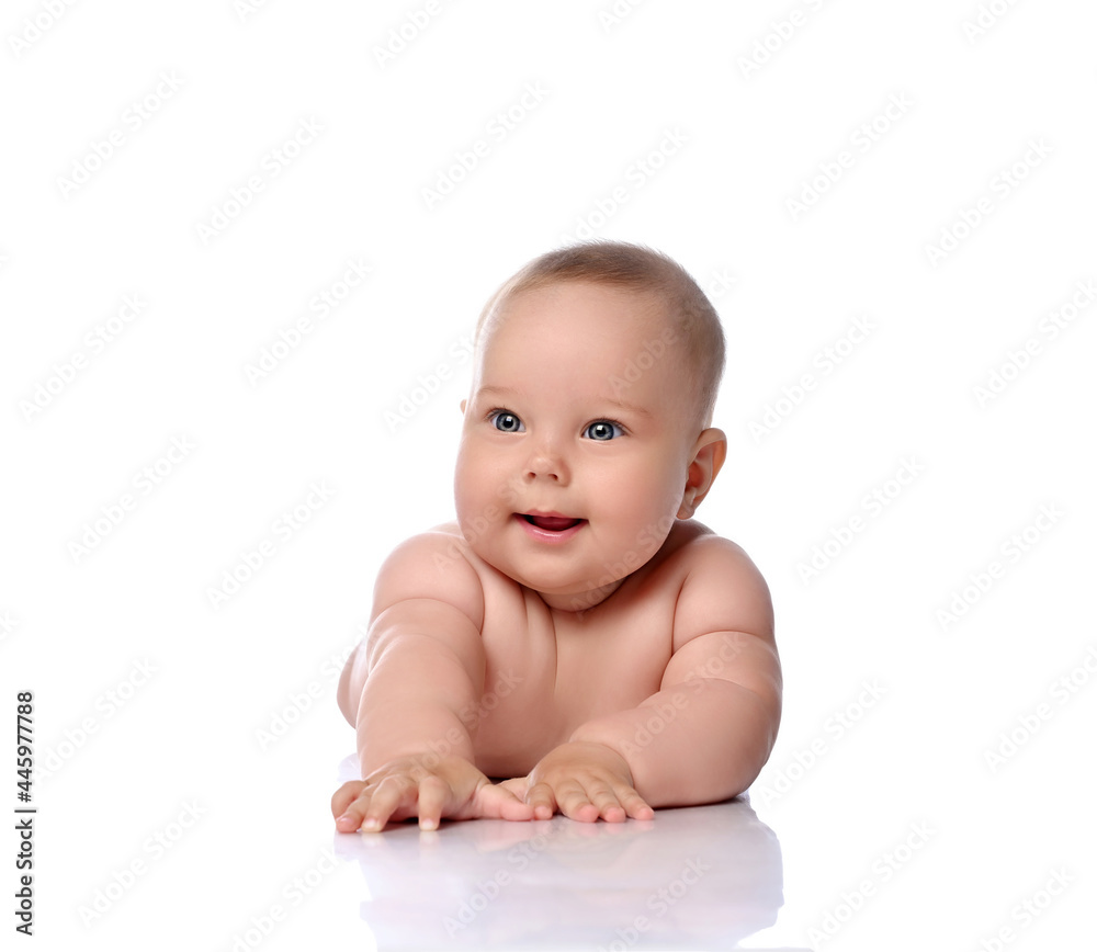 Happy, surprised, amazed infant child baby girl kid in diaper is lying on her stomach holding arm outstretched isolated on a white background Happy, surprised, amazed infant child baby girl kid in diaper is lying on her stomach holding arm outstretched isolated on a white background