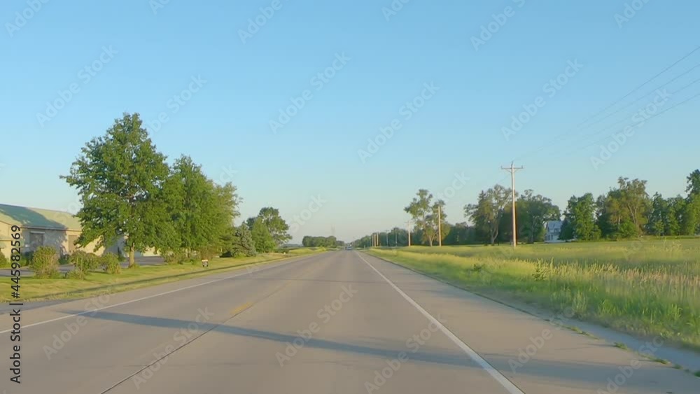 POV while driving on a country highway past farms and fields; landscape is very flat POV while driving on a country highway past farms and fields; landscape is very flat