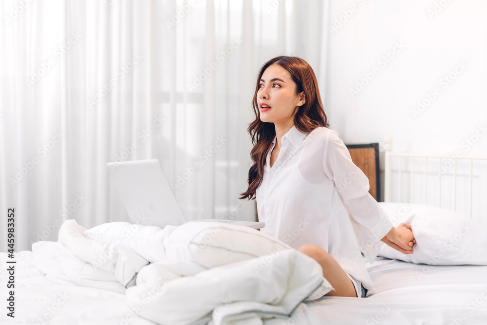 Portrait of smiling cheerful beautiful pretty asian woman clean fresh healthy white skin posing in pajamas white clothes.Girl felling relaxing and enjoy time on the bed at home.asia beauty