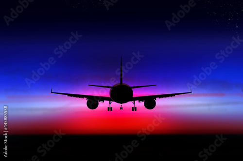 Airplane in the dark sky on the background of the sunset