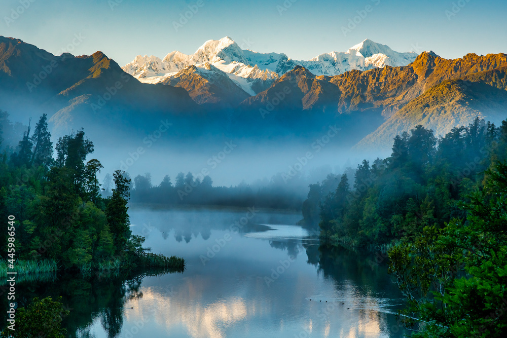 Mist at dawn  preventing the reflections of the snow capped southern alps on the calm water at Lake Matheson